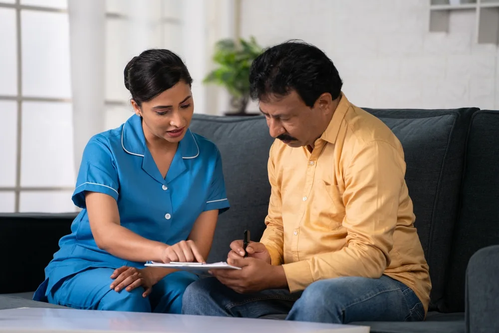 A nurse going through a health policy with a client at home